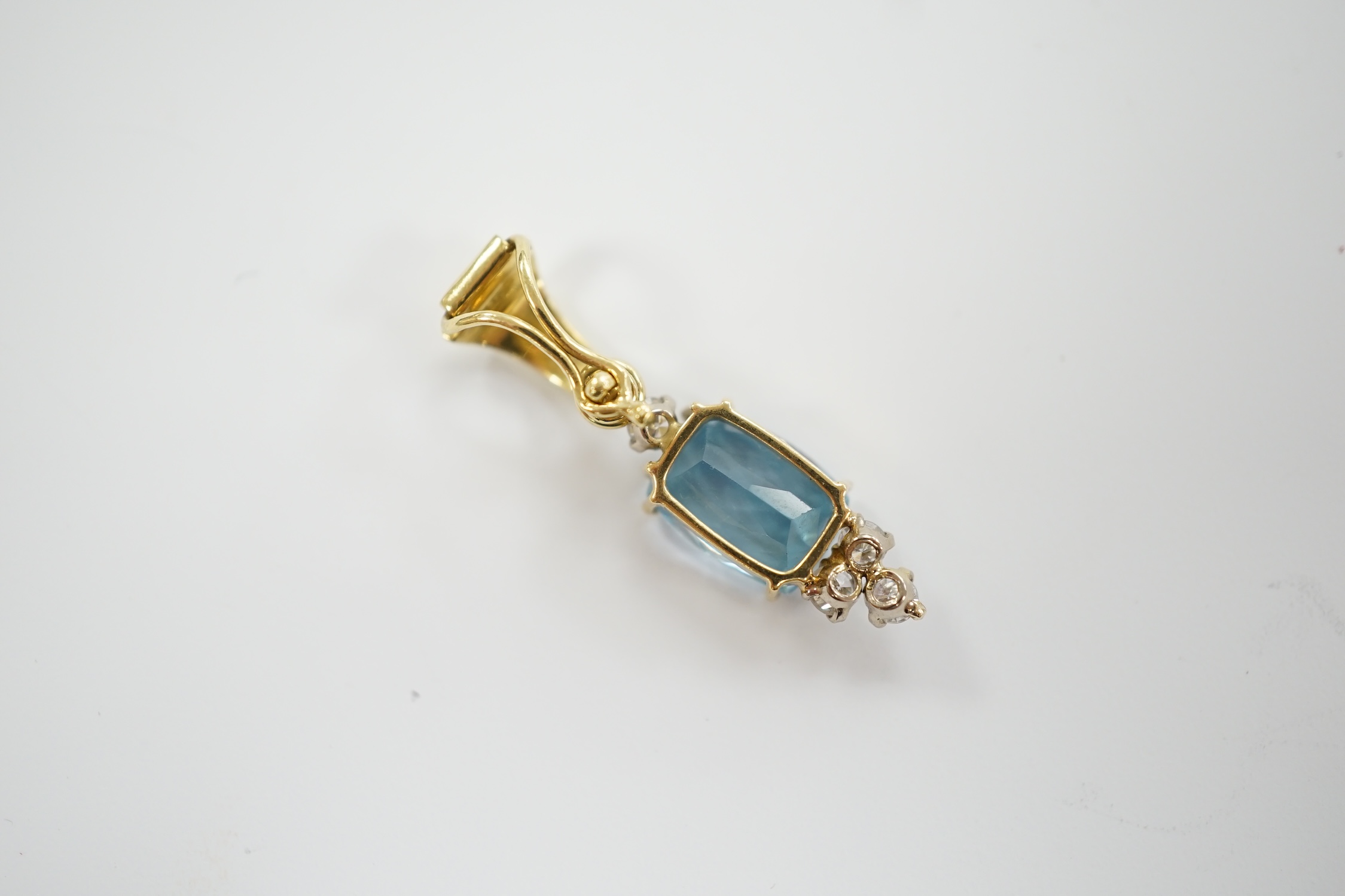 A yellow metal, single stone blue topaz and four stone diamond set pendant, overall 28mm, gross weight 2.6 grams.